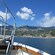 The front of a boat heading to civilization on a mountainous shoreline